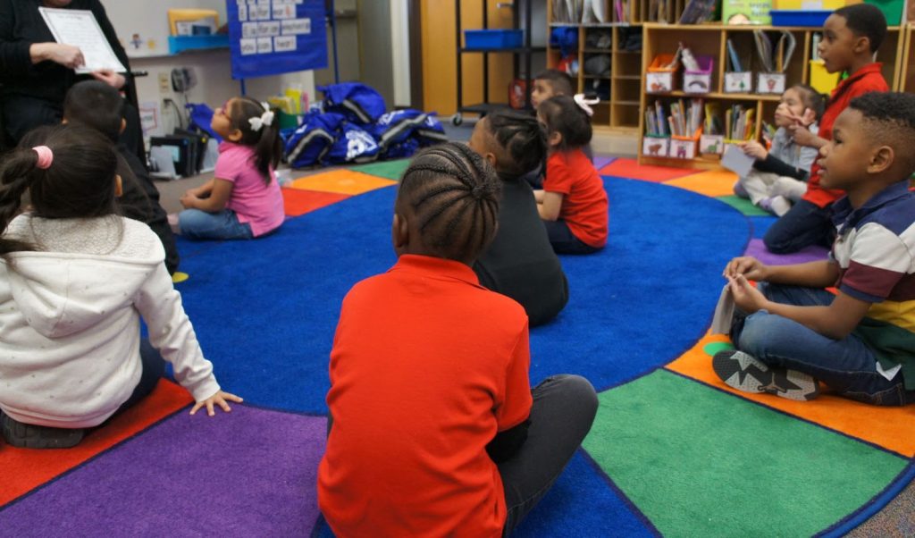 Students sitting on the floor in class