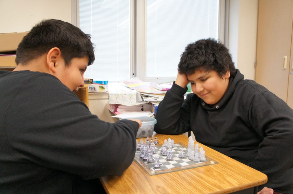 Two students playing chess in class