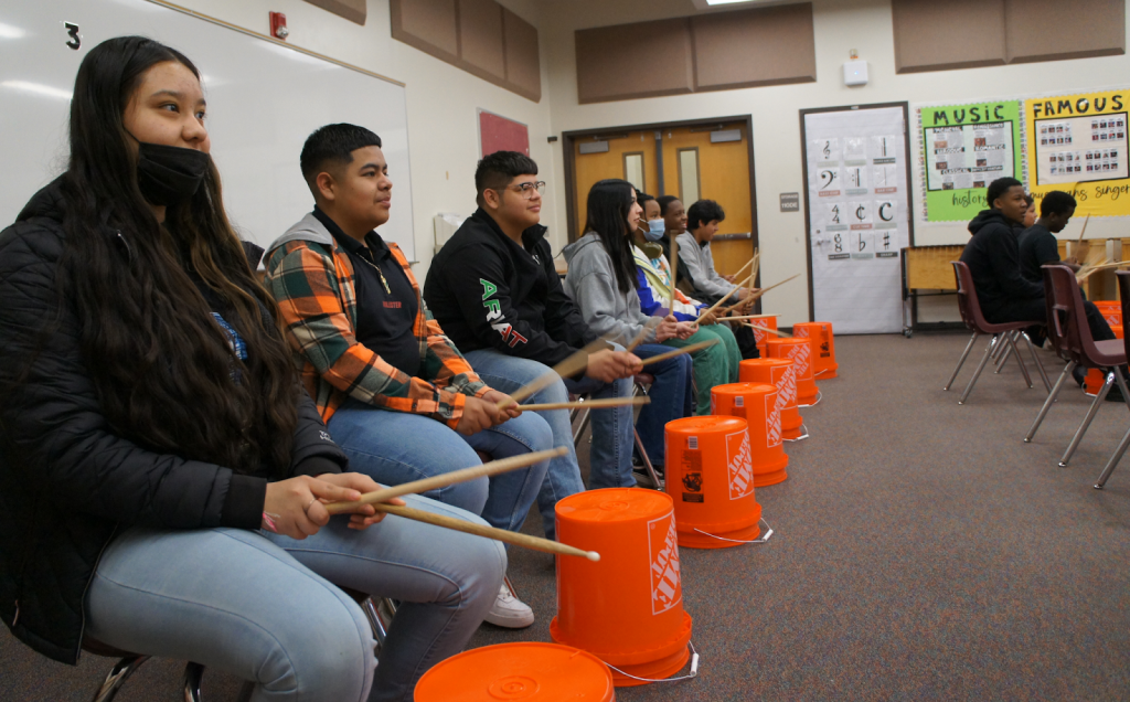 Students playing drums in class